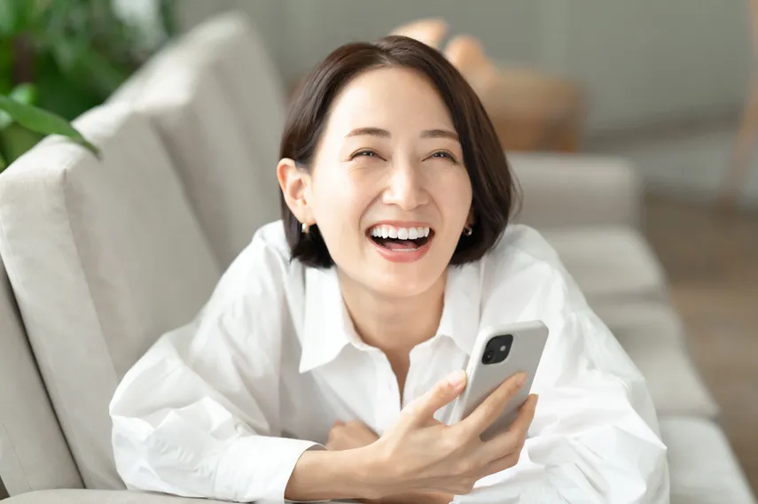 笑顔でスマホを操作する女性