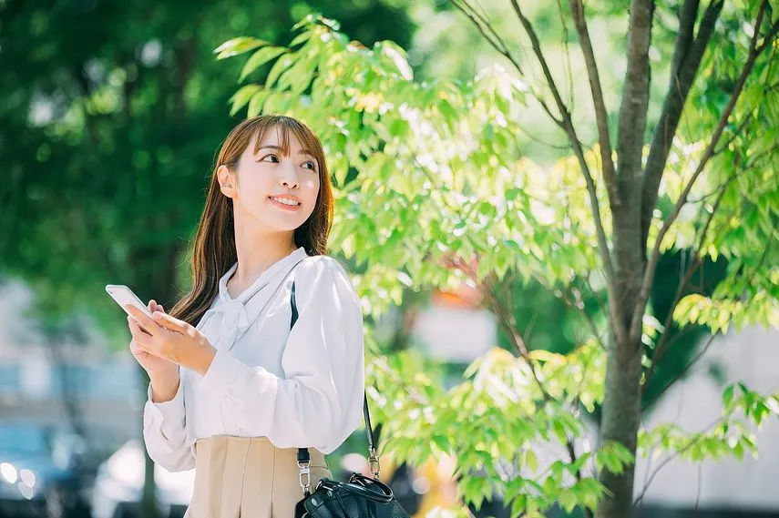屋外でスマホを使うビジネスウーマン