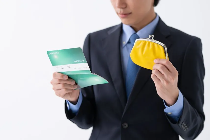 財布と通帳を持つ若いビジネスマン
