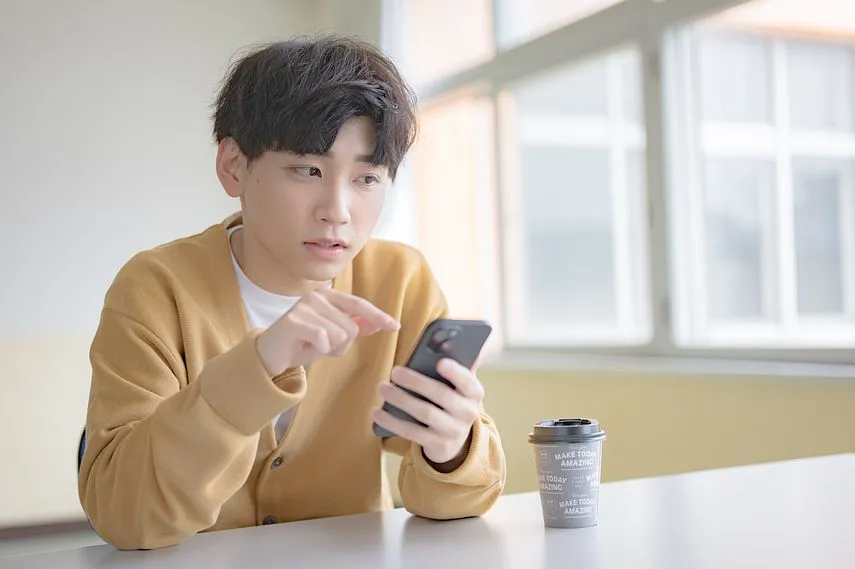 スマホを持つ人の画像
