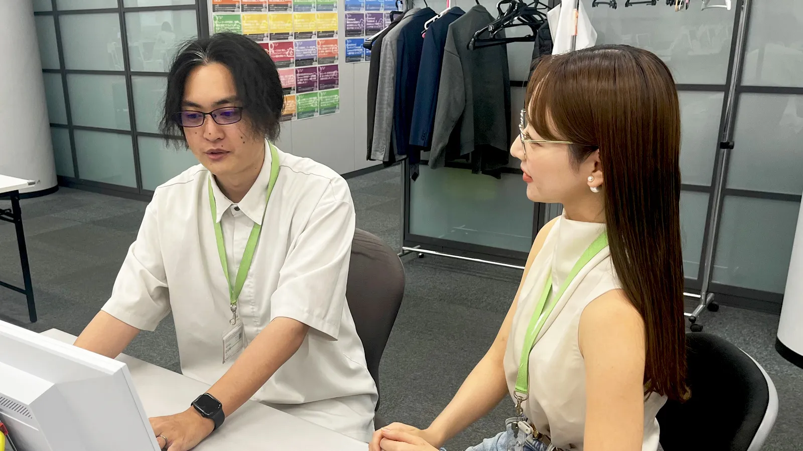 PCに向かい、DX推進について話し合う二人