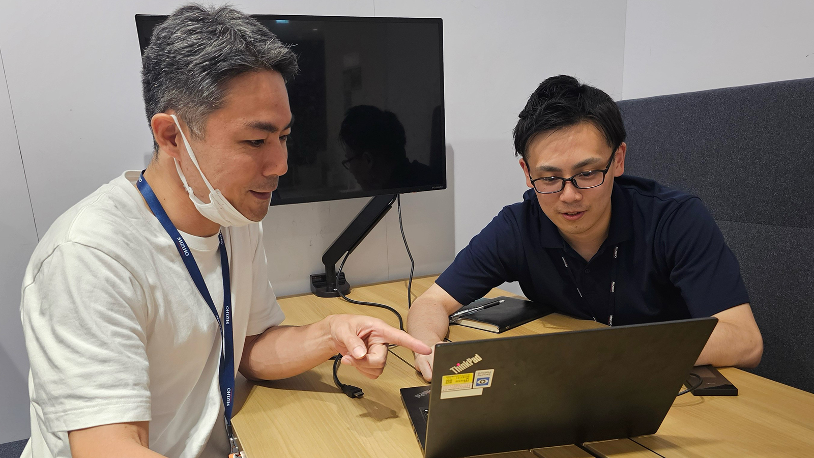 メンバーとPCの前で話し合いをしている松田さん