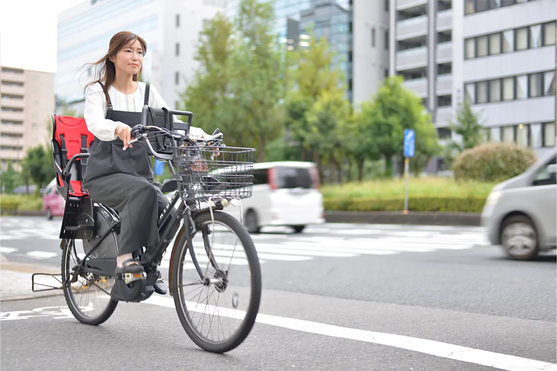 自転車に跨り保育園へお迎えに行く社員