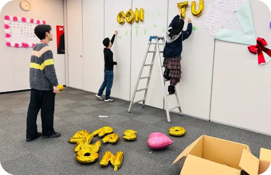 イベントのために会議室を飾り付ける3名