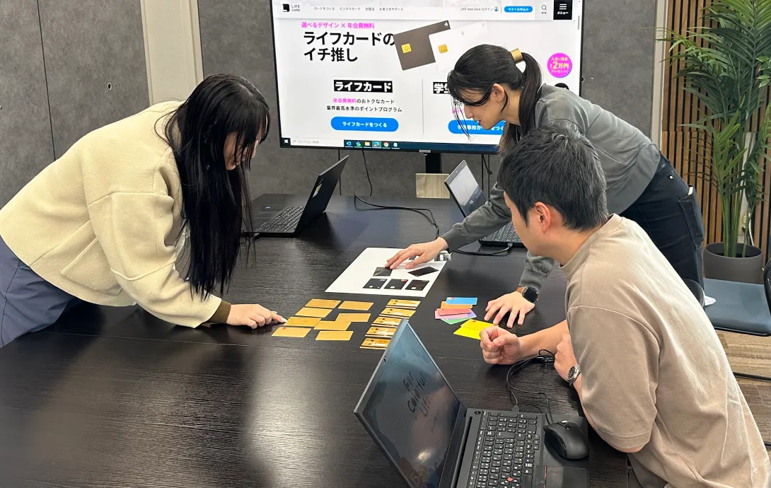 クレジットカードの券面デザインの打ち合わせをしている3名の社員