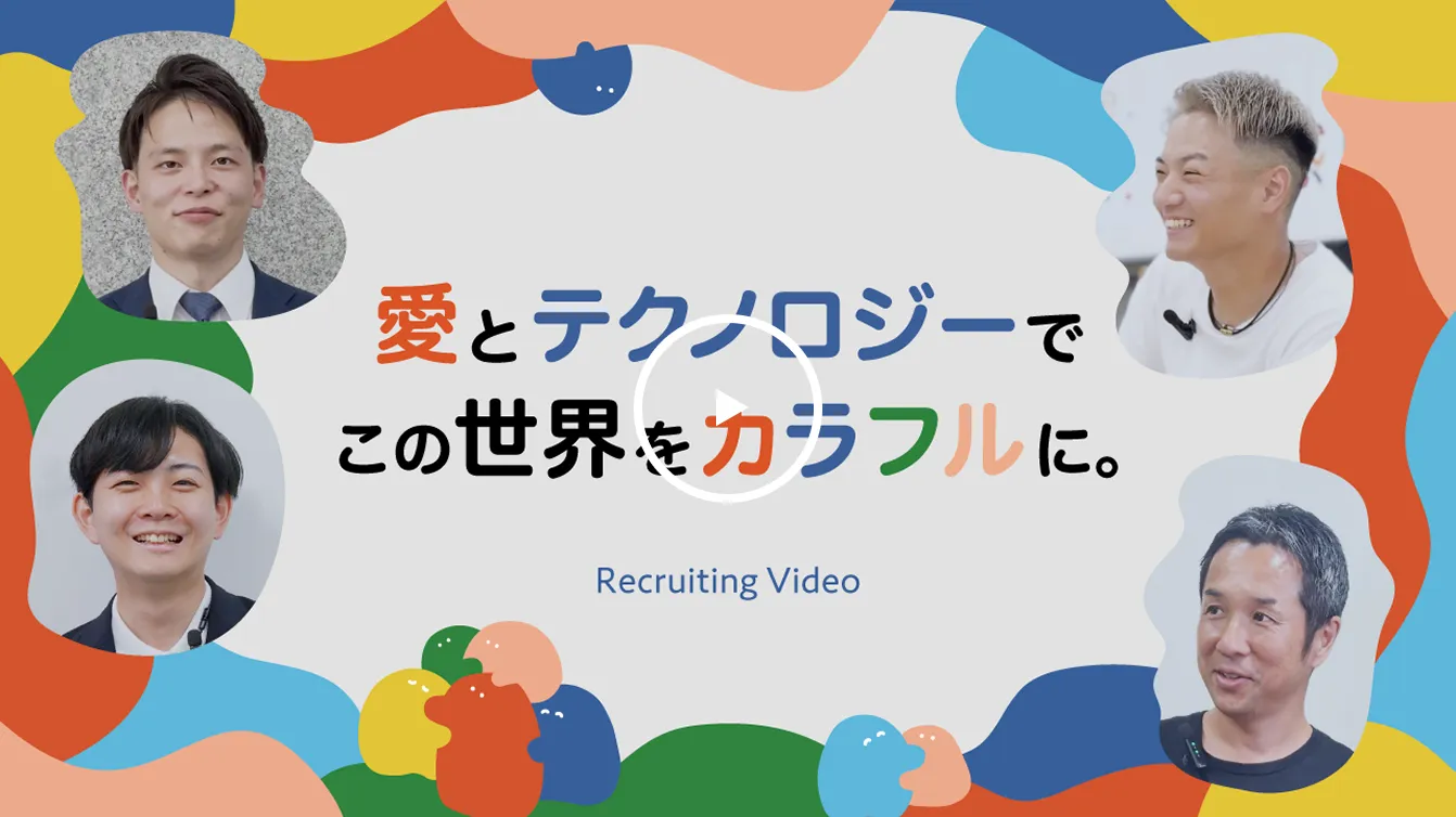 新卒採用動画再生ボタン。「愛とテクノロジーでこの世界をカラフルに。Recruiting Video」の文字と、4名の社員の顔写真が写っている