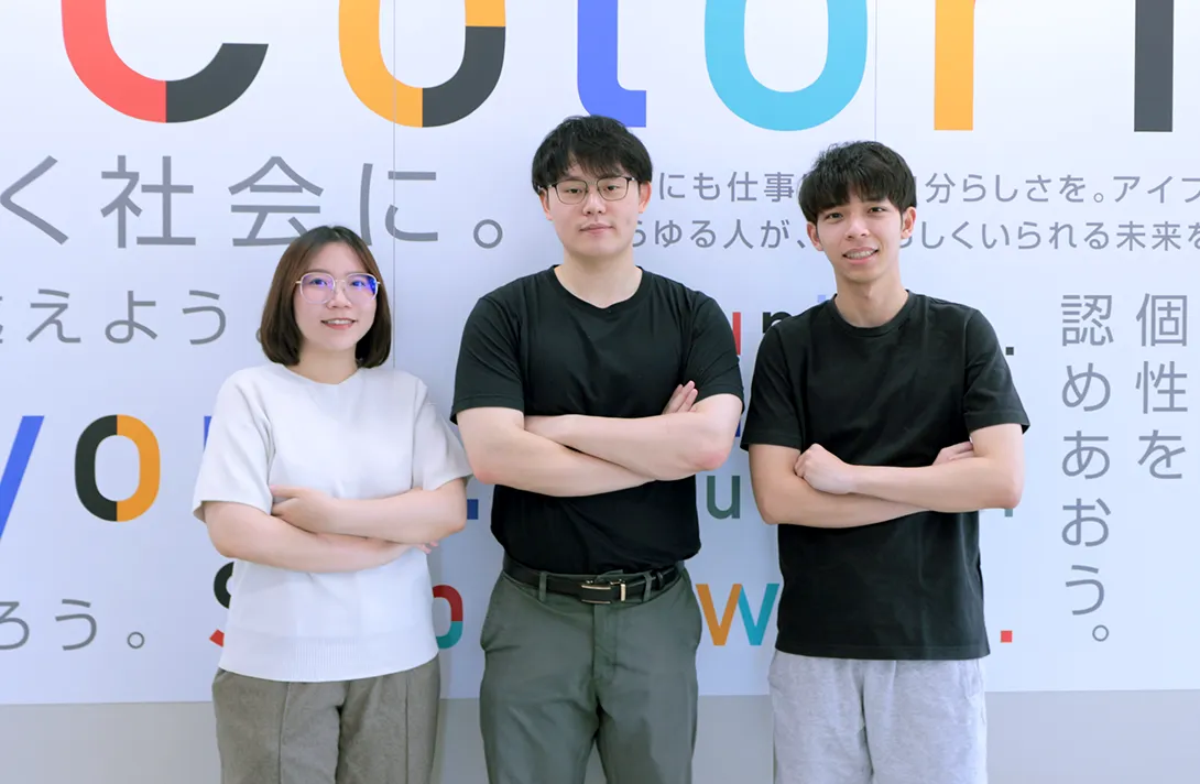 横に並んで腕組みのポーズをし、こちらに向かってほほ笑む海外人材三名